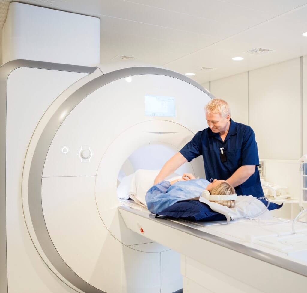 Male Radiologist Preparing Woman for MRI Scan
